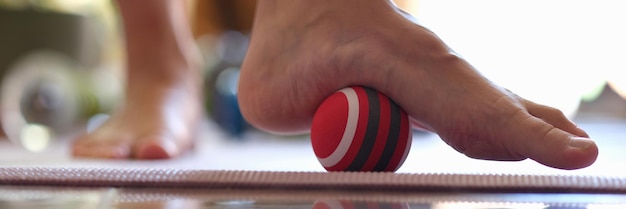 Myofascial relaxation of hypermobile muscles of foot with a massage ball closeup