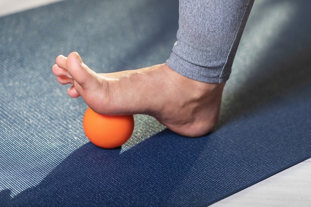 Myofascial relaxation of hypermovable muscles of the foot with a massage ball on a gymnastic mat