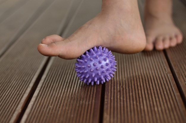 Myofasciale ontspanning van de spieren van de voet met een massagebal thuis close-up