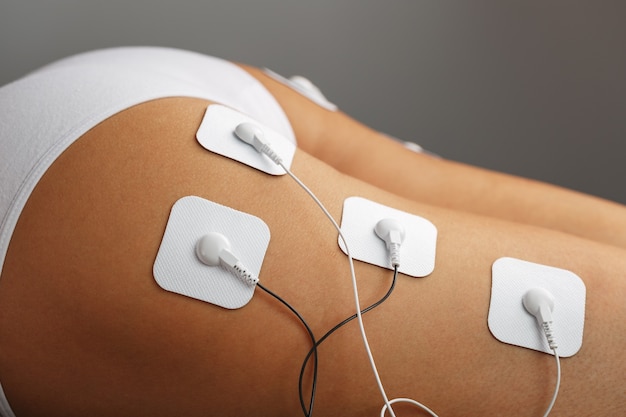 Photo myostimulation electrodes on the buttocks and legs of a woman in a beauty salon. rehabilitation and treatment, weight loss.