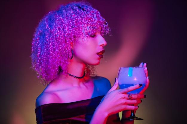 Mysterious afro woman holding a night beverage on halloween