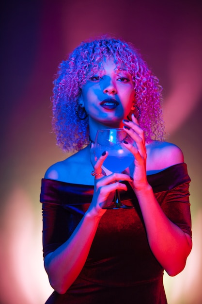 Mysterious black woman at a nightclub with a blue drink