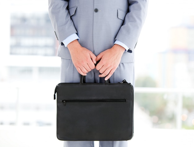 Photo mysterious businessman holding a briefcase