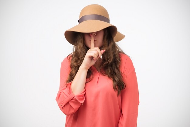 Mysterious girl in hat gesture silence sign holding forefinger on lips