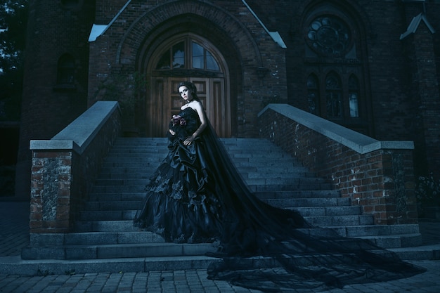 Photo mysterious woman in black dress near church