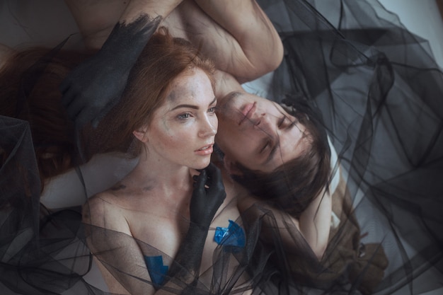 Mystical couple beauty portrait with veil, studio shot, closeup