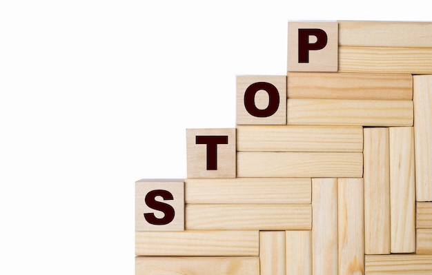 N a light background, wooden blocks and cubes with the text STOP