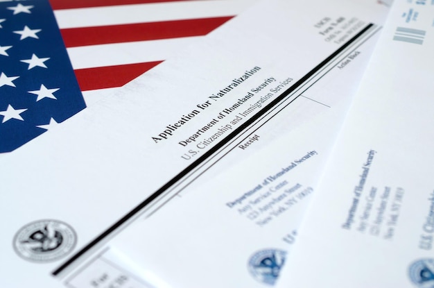 N400 Aanvraag voor naturalisatie blanco formulier ligt op Amerikaanse vlag met envelop van Department of Homeland Security