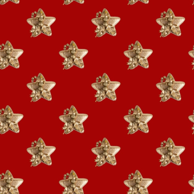 Foto naadloos patroon van kerstmisdecoratie in vorm van gouden ster tegen heldere rode achtergrond