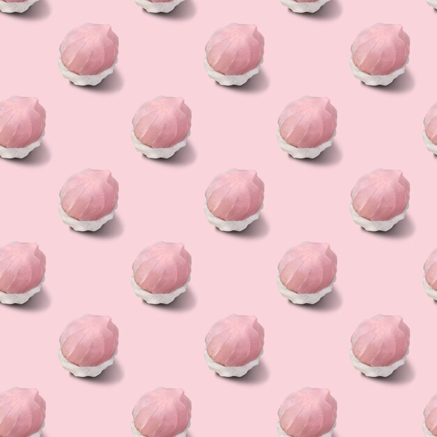 Naadloos patroon van tweekleurige witte en roze marshmallows op een roze ondergrond