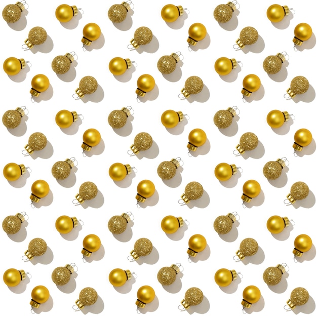 Naadloos regelmatig creatief patroon met heldere glanzende kleine gouden geïsoleerde kerstballen