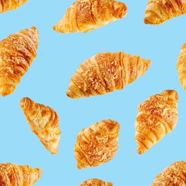 Naadloze patroon gemaakt van verse croissants met kaas geïsoleerd op blauwe achtergrond