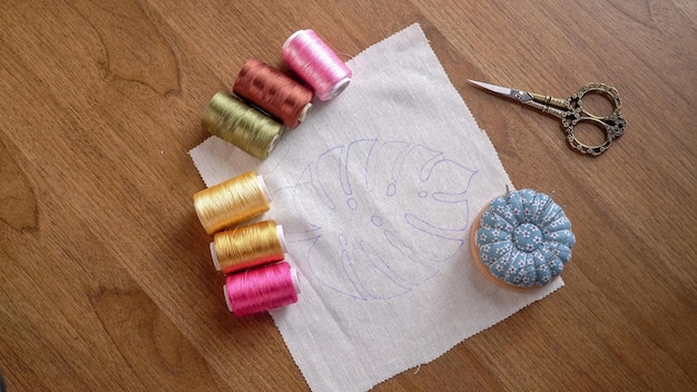 Naaiaccessoires op een houten tafel Spoelen van draad schaar naalden en floss bobbins