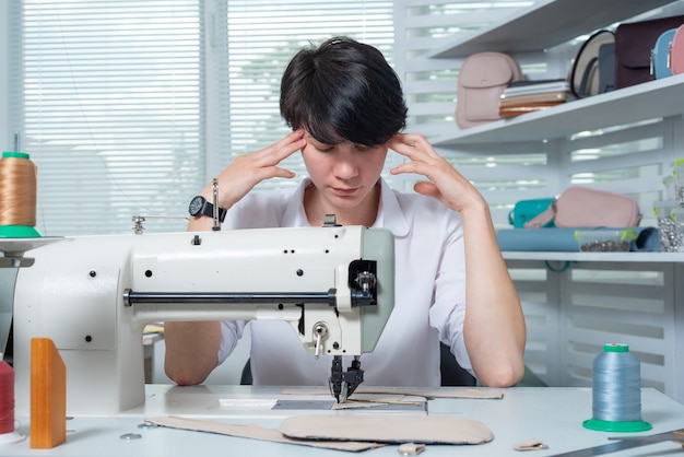 Naaister meisje is op de werkplek achter de naaimachine