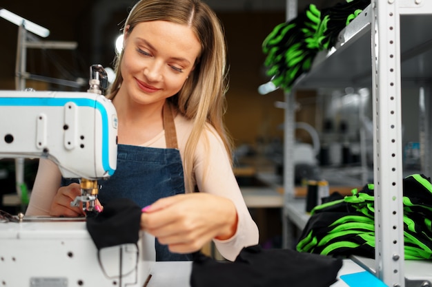 Naaister vrouw op haar werkplek naaien kleding op naaimachine