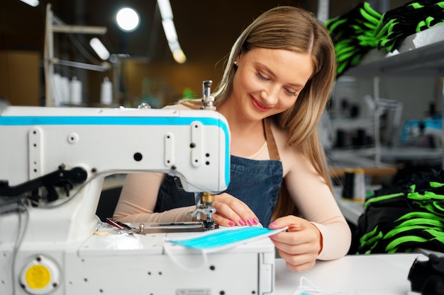 Naaister vrouw op haar werkplek naaien kleding op naaimachine