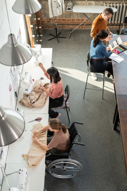 Foto naaisters en ontwerpers werken aan nieuwe modecollectie in werkplaats