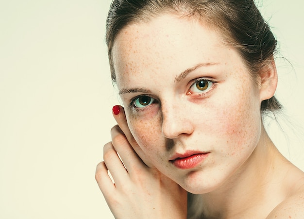 Naakt schouders mooie sproeten vrouw gezicht portret jonge. Blauwe achtergrond.