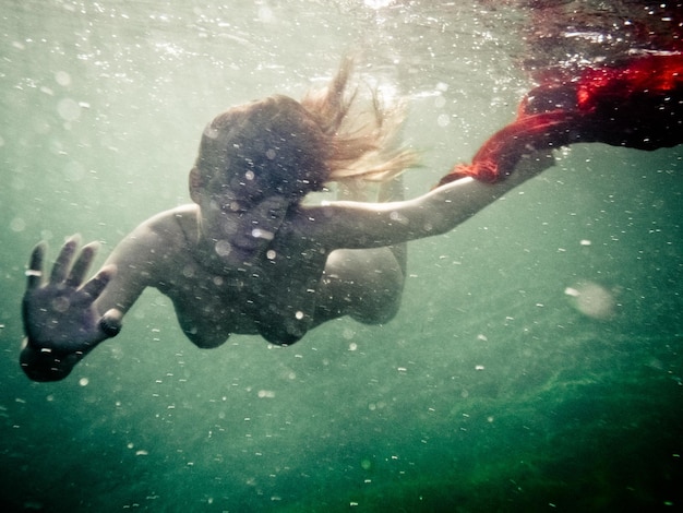 Foto naakte vrouw zwemt in de zee.