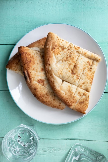 Naan Indian flatbread with garlic on a turquoise wooden background traditional Indian cuisine