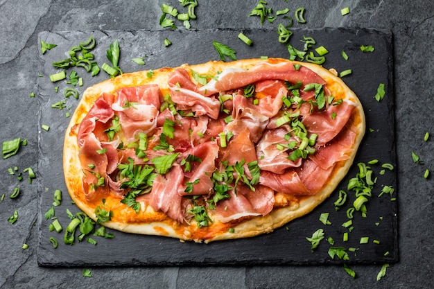 Naan pizza met ham serrano op leisteen bord