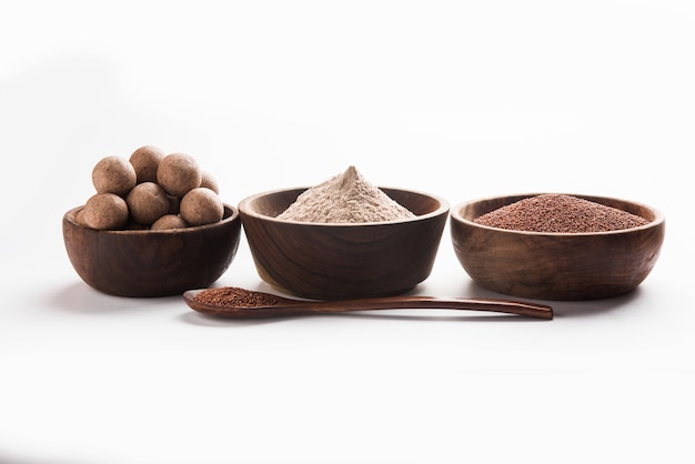 Nachni laddu of Ragi laddoo of balletjes gemaakt van vingergierst, suiker en ghee. Het is een gezond voedsel uit India. Geserveerd in een kom of bord met rauw geheel en poeder. Selectieve focus