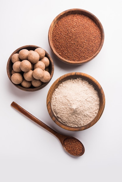 Nachni laddu of Ragi laddoo of balletjes gemaakt van vingergierst, suiker en ghee. Het is een gezond voedsel uit India. Geserveerd in een kom of bord met rauw geheel en poeder. Selectieve focus