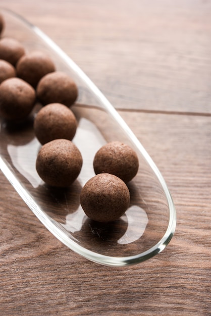 Nachni laddu or Ragi laddoo or balls made using  finger millet, sugar and ghee. It's a healthy food from India. Served in a bowl or plate with raw whole and powder. Selective focus