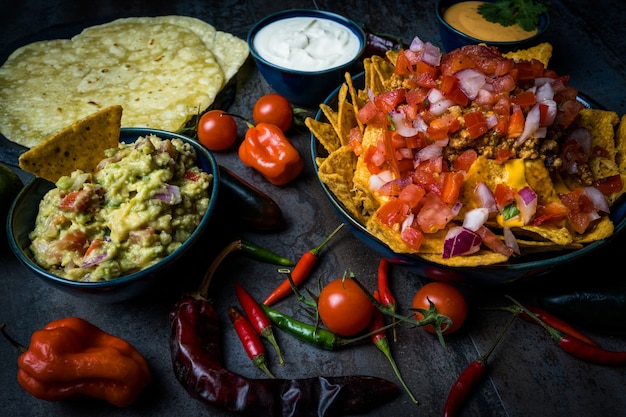 Nachos and chedar cheese with guacamole sour cream peppers adn tortilla pico de gallo