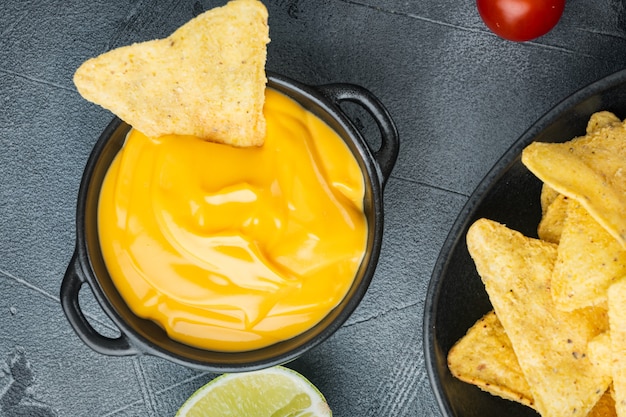 Chip di tortilla di mais nachos con salsa al formaggio, sul tavolo grigio, vista dall'alto o piatto