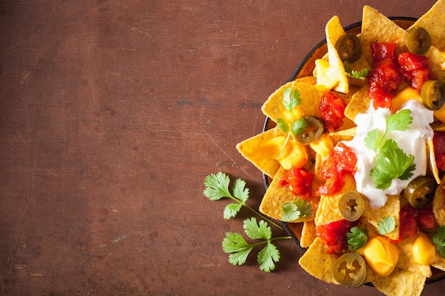 Foto nachos carichi di salsa, formaggio e jalapeno