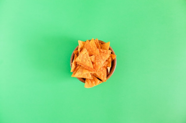 Nachos maïs chips in een houten kom op groen