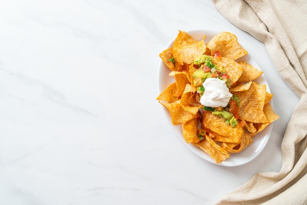 Nachos tortilla chips with jalapeno guacamole tomatoes salsa and dip