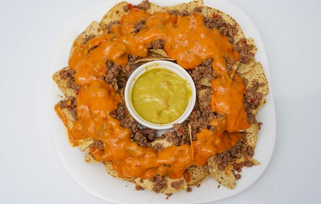 Nachos with cheese meat guacamole and tomato