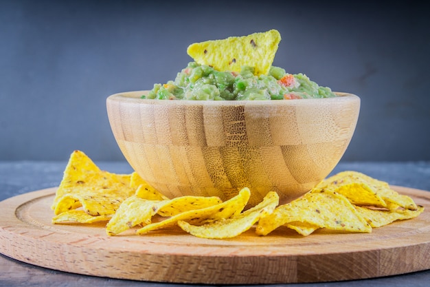 Nachos with guacamole on a gray background