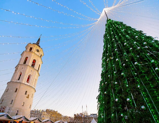 Nacht stadsgezicht met kerstmarkt op het plein van de kathedraal in Winter Vilnius, Litouwen. Advent Fair Decoratie en kraampjes met ambachtelijke artikelen op de bazaar. Litouwse straat. Geselecteerde focus