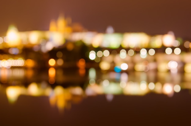 Nacht uitzicht op de beroemde Europese stad Praag - de hoofdstad van Tsjechië met reflectie in de rivier de Moldau en historische bruggen - wazig intreepupil achtergrond