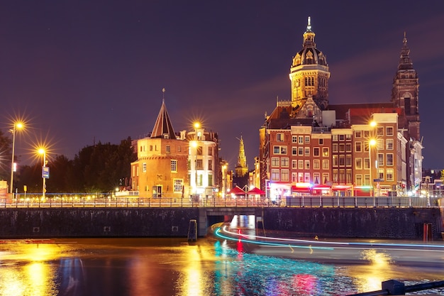 Nacht uitzicht op de stad van amsterdamse gracht en basiliek van sint nicholas schreierstoren of weepers toren