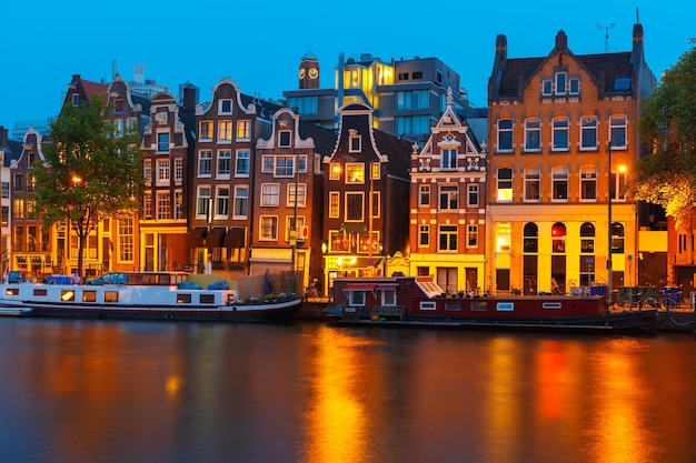 Nacht uitzicht op de stad van Amsterdamse gracht, typisch Nederlandse huizen en boten, Holland, Nederland.