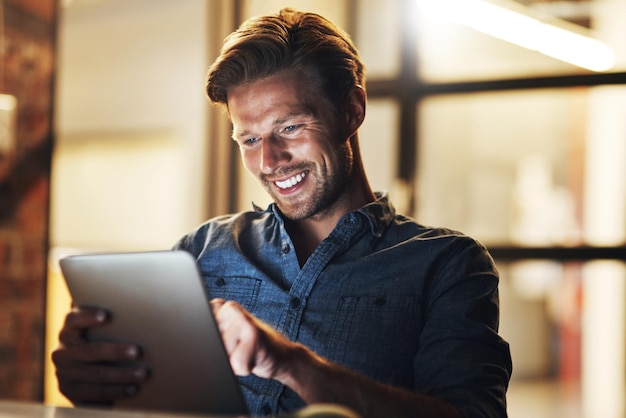 Nacht zaken en man met een tablet internet en glimlach met verbinding project en online lezen Persoon avond en werknemer met technologie e-mail melding en communicatie met onderzoek