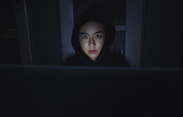 Nachthacker en cyberbeveiliging met vrouw en laptop voor het coderen van software en programmeren Ransomware phishing en ontwikkelaar met meisjesprogrammeur in server voor databasenetwerk en digitale misdaden