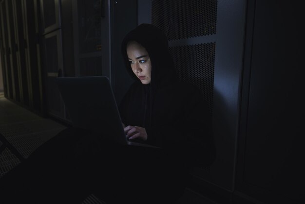 Nachthacker en programmeren met vrouw en laptop voor het coderen van software en cyberbeveiliging Ransomware phishing en ontwikkelaar met meisjesprogrammeur in server voor databasenetwerk en digitale misdaden
