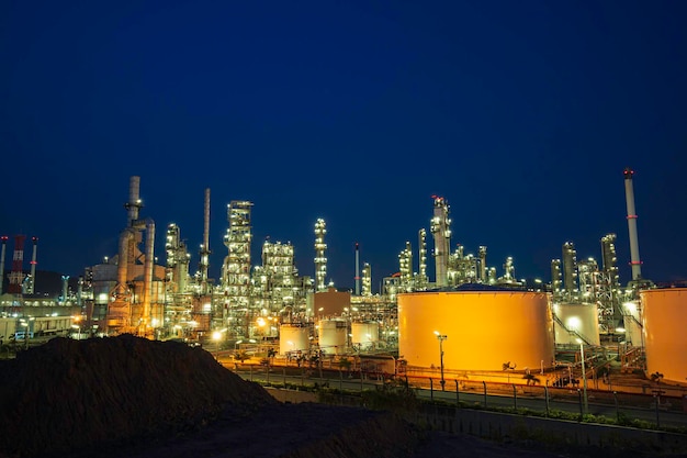 Nachtscène van olieraffinaderij en opslag witte tankolie van de petrochemie-industrie