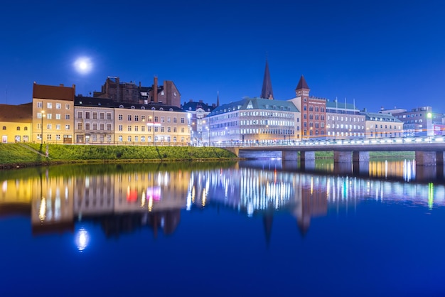 Nachtstad weerspiegeld in het water. Avondpanorama van een oude Europese stad. Stadsgezicht van Malmö, Zweden