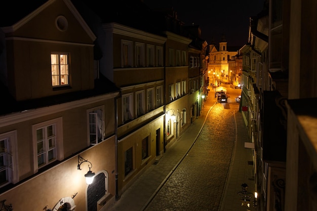 Nachtzicht op de Europese oude stadsstraat vanuit een open raam 's nachts in Warschau, Polen