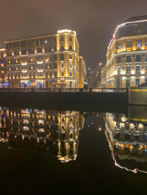 Nachtzicht op de stad met selectieve focus Neonlichten van de stad worden 's nachts weerspiegeld op de rivier