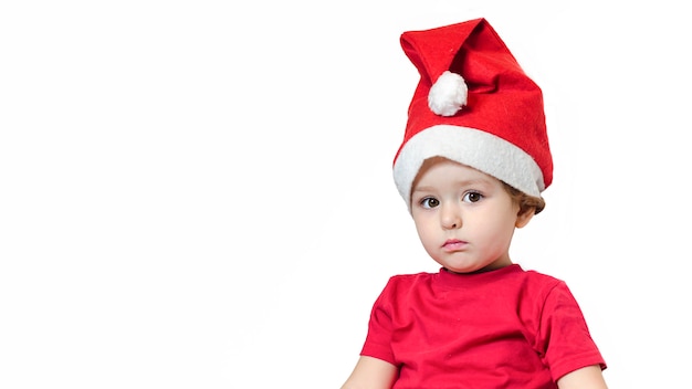 Nadenkend boos meisje in rood pak en kerstmuts op Nieuwjaar. baby wacht geschenk op cristmas.