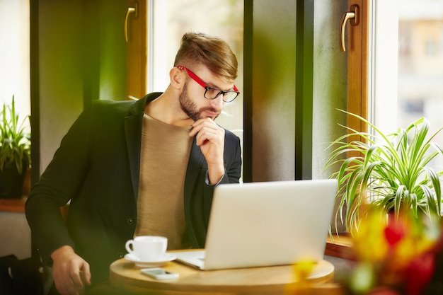 Nadenkend man op laptop