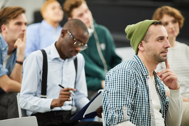 Foto nadenkend multi-etnische studenten op conferentie