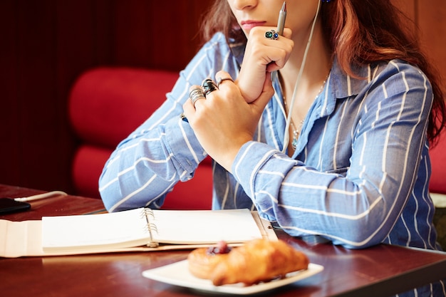 Nadenkend vrouw die in café werkt